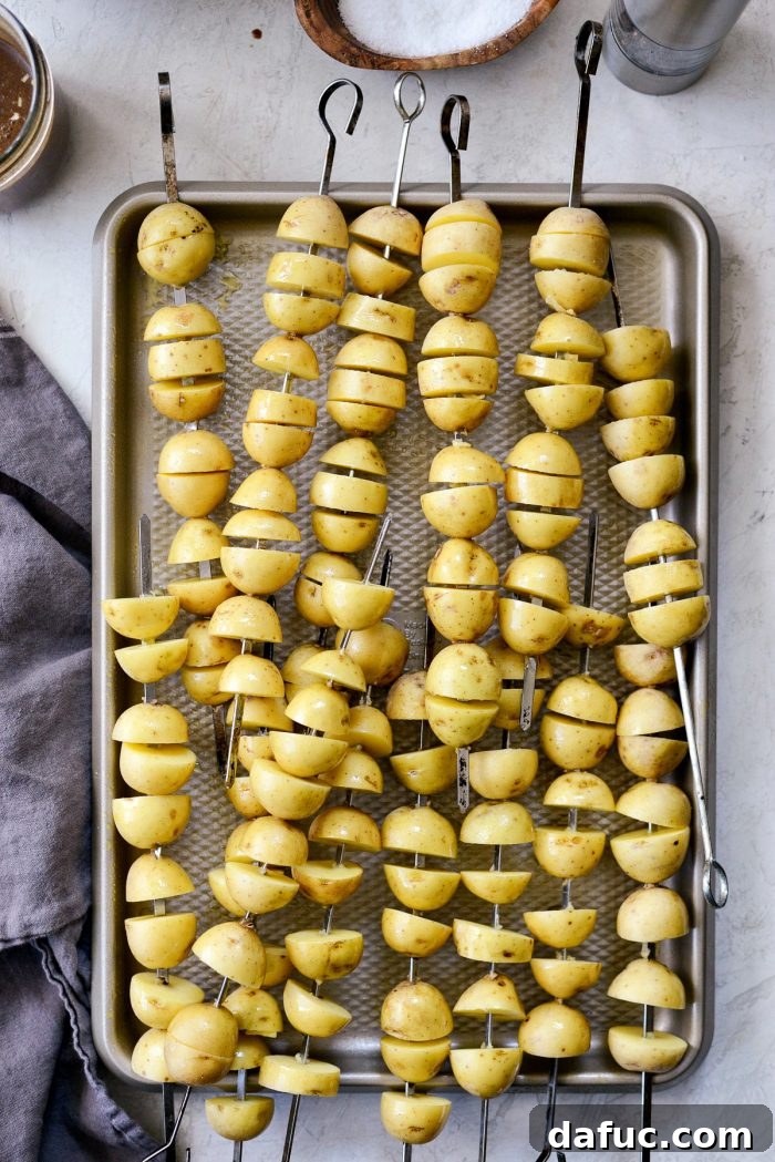 Baby Yukon gold potatoes threaded onto metal skewers.