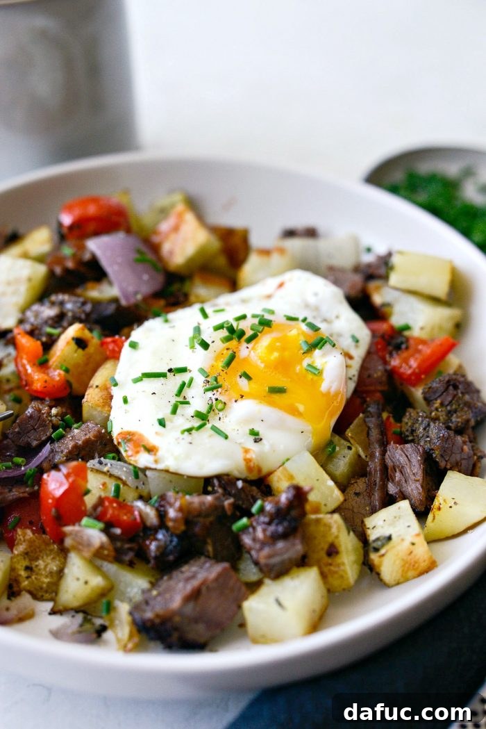 Smoked Brisket Breakfast Hash 11 Close-up of Smoked Brisket Breakfast Hash with a fried egg and a perfectly broken yolk, ready to be enjoyed.
