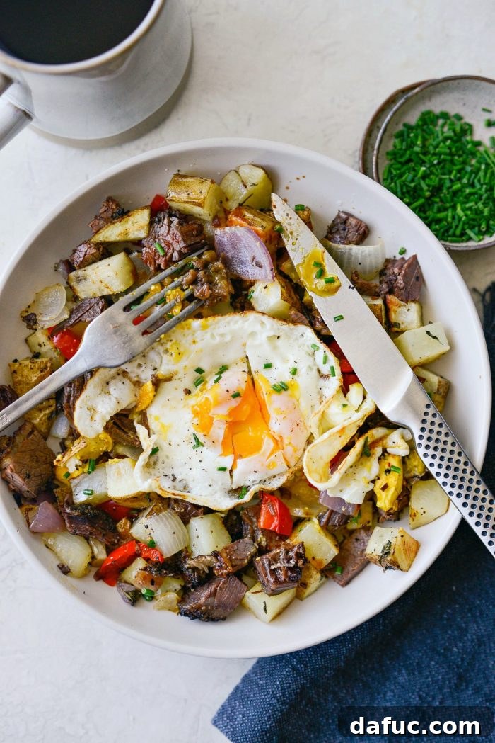 Smoked Brisket Breakfast Hash 13 A beautifully presented serving of smoked brisket breakfast hash with a golden fried egg and fresh chives.