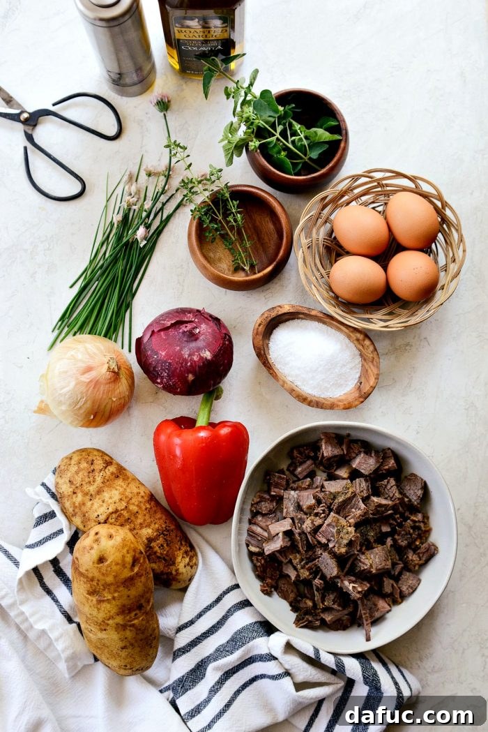 Smoked Brisket Breakfast Hash 3 Close-up of fresh ingredients for Smoked Brisket Breakfast Hash, including potatoes, onions, bell pepper, and fresh herbs.