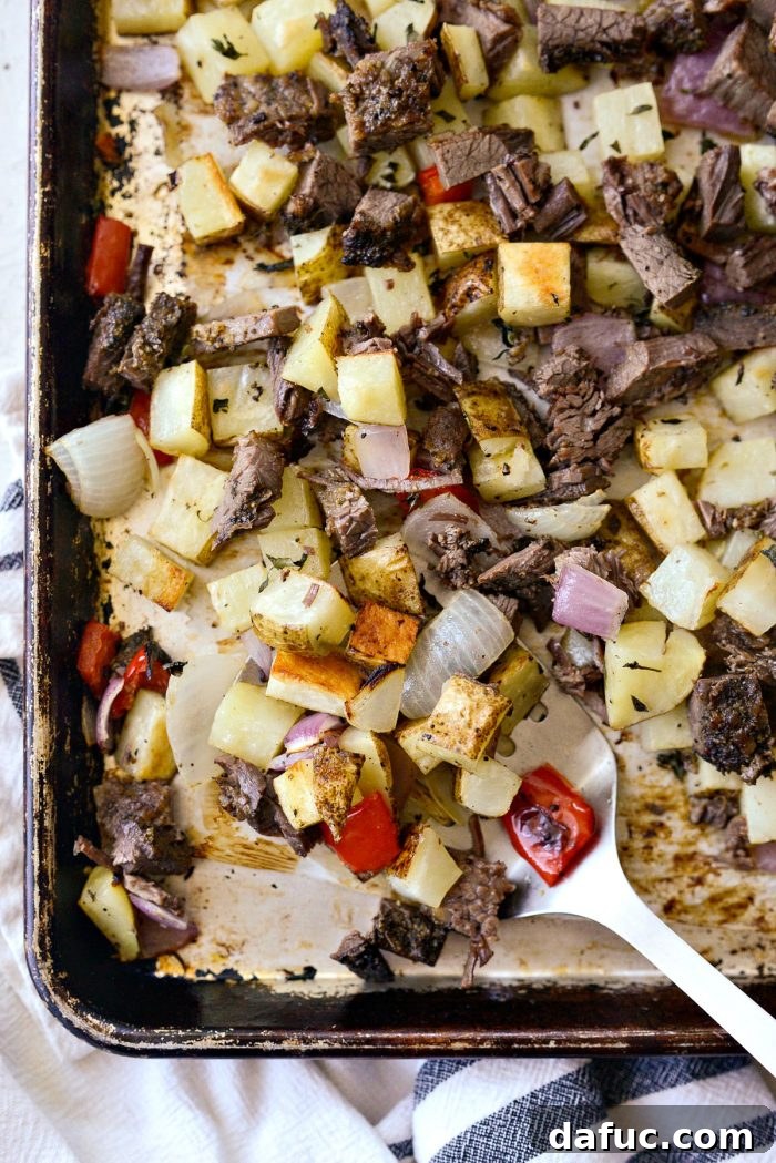 Smoked Brisket Breakfast Hash 9 A metal spatula scooping a generous portion of Smoked Brisket Breakfast Hash from the sheet pan.