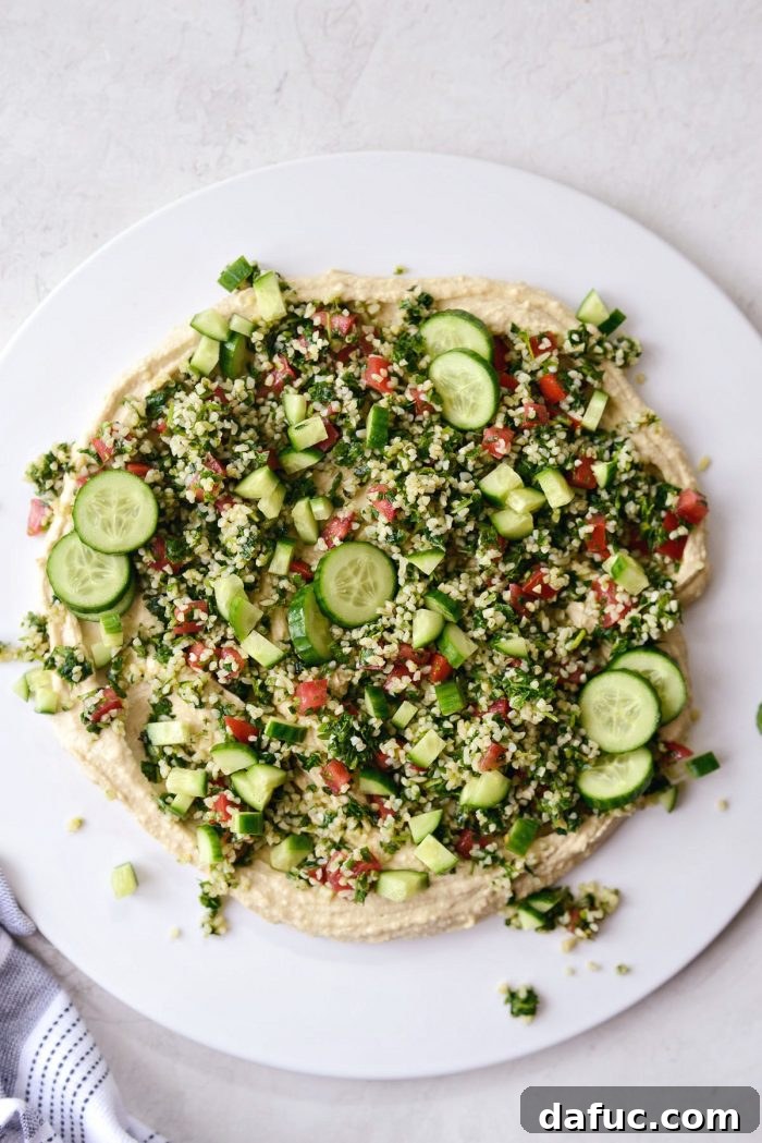 Hummus base topped with fresh tabbouleh and diced cucumbers
