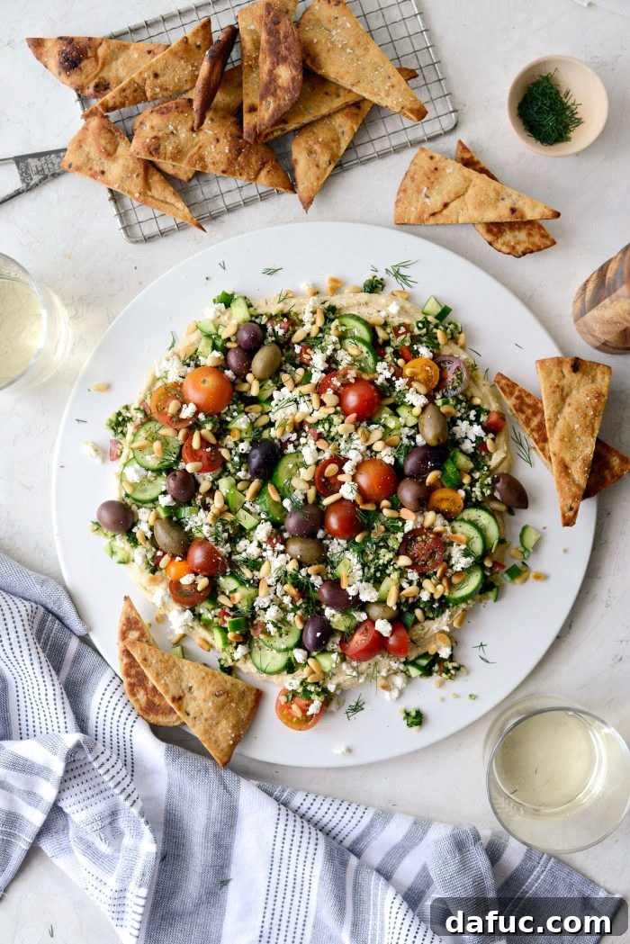7-Layer Loaded Hummus Dip served with golden toasted naan triangles