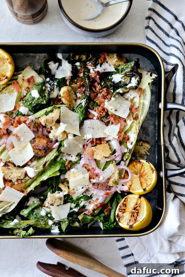 Grilled Romaine Salad on a black metal serving tray, showcasing its vibrant toppings and charred edges