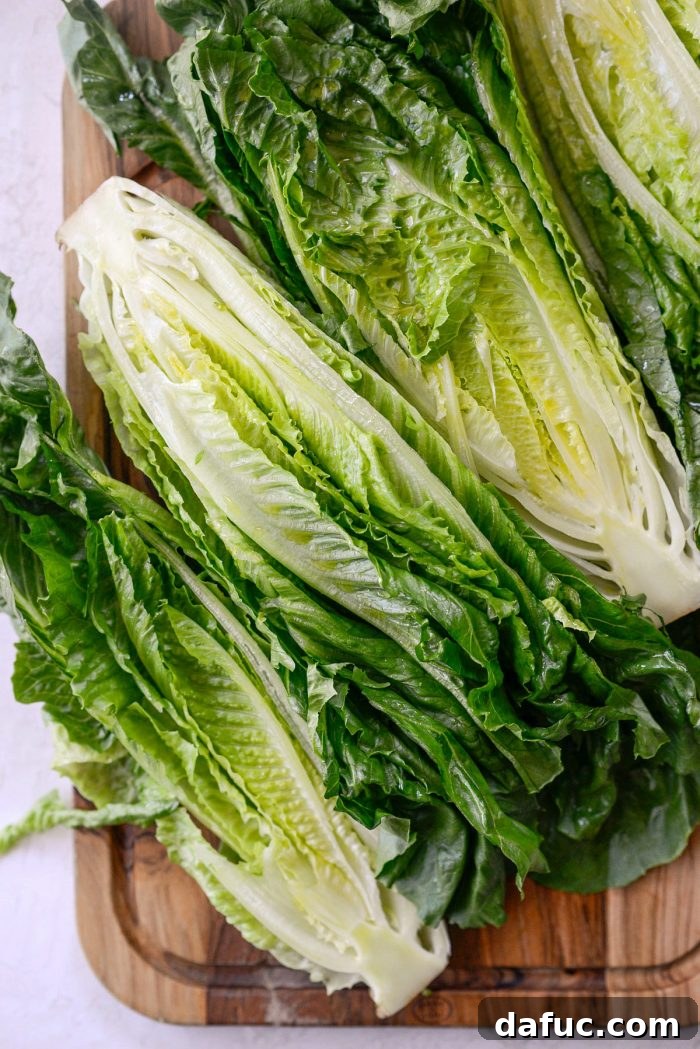 Close-up of romaine lettuce halves seasoned with kosher salt after being brushed with olive oil