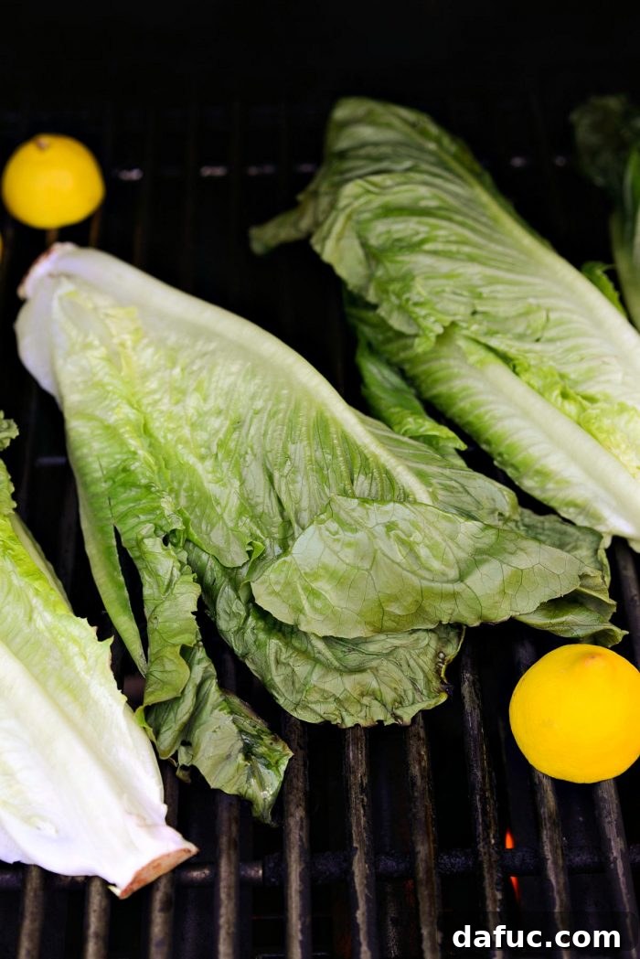 Romaine lettuce halves grilling on a hot barbecue, showing developing char marks