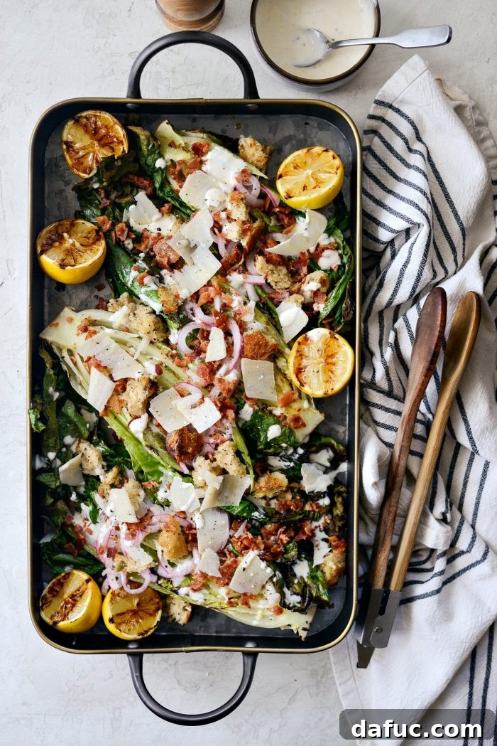 Grilled Romaine Salad fully assembled with bacon, parmesan, pickled red onions, croutons, and creamy lemon dressing