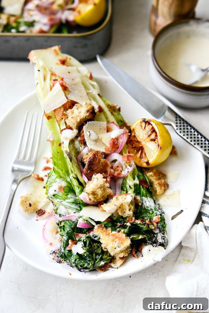 Close-up of a beautifully plated Grilled Romaine Salad, highlighting the creamy dressing and colorful toppings