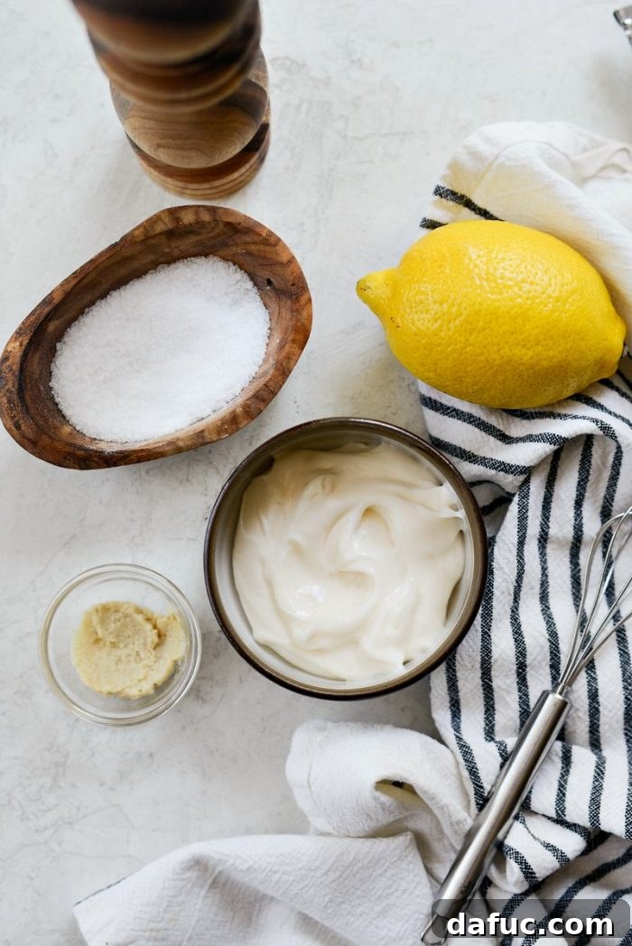 Ingredients for creamy lemon dressing laid out, including mayonnaise, garlic, and lemon