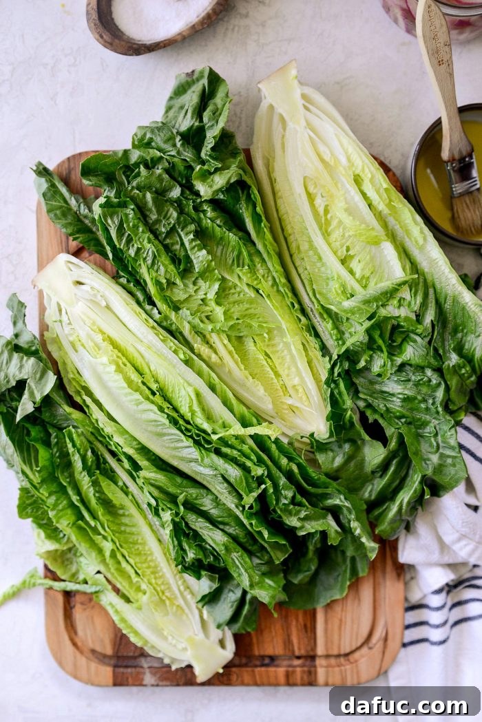 Romaine lettuce heads sliced lengthwise on a cutting board
