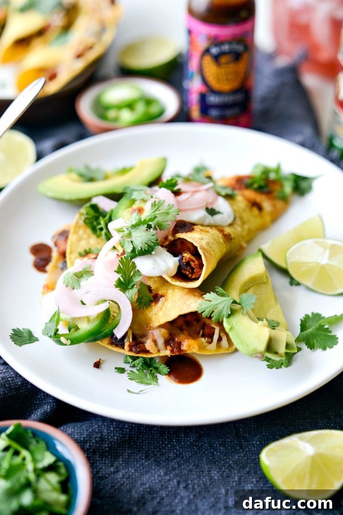 Crisp air fried chipotle chicken black bean tacos with fresh cilantro, a dollop of jalapeño crema, and pickled red onions on top.