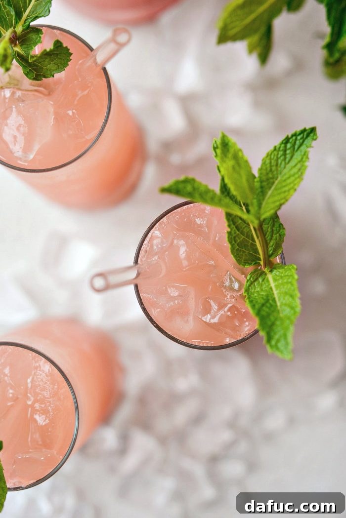 Close-up of a glass of watermelon lemonade, showing its refreshing texture and color.
