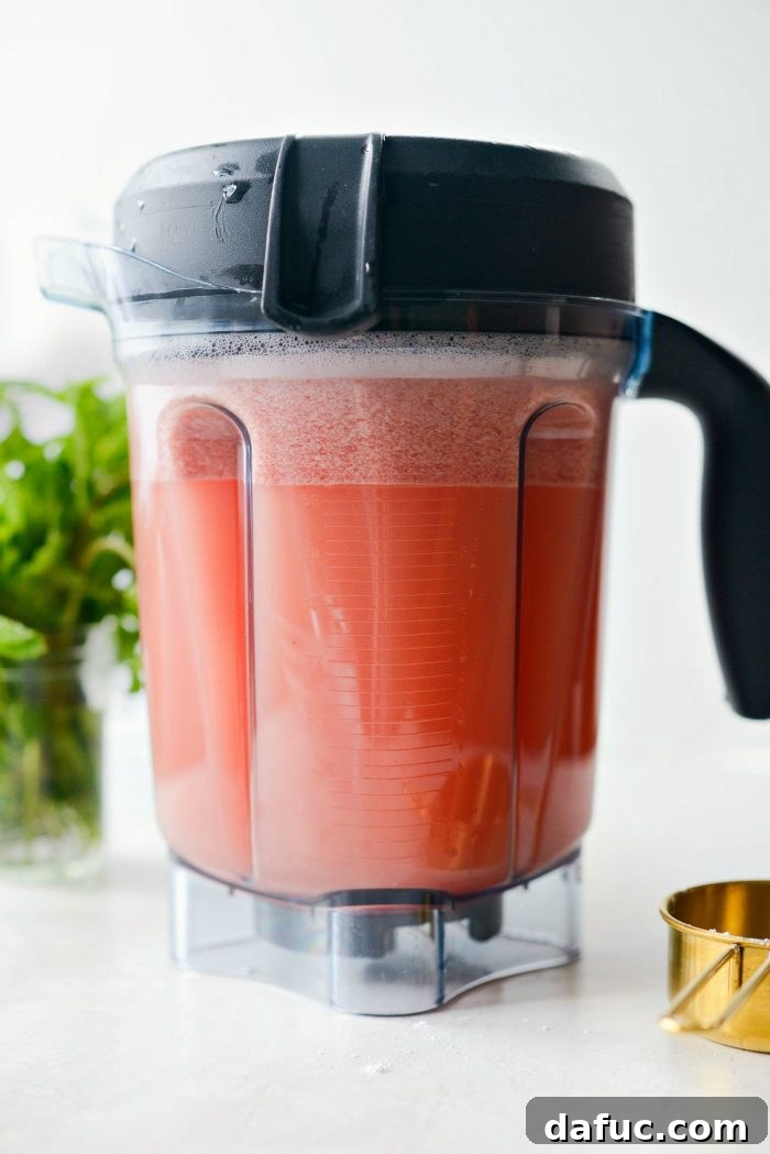 Close-up view of the vibrant pink, pureed watermelon lemonade inside the blender, showing its smooth consistency.