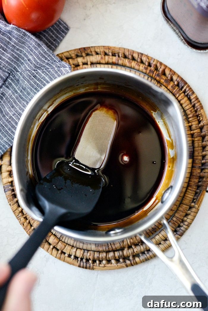 Reduced balsamic glaze coating the back of a spoon, showing its thick texture