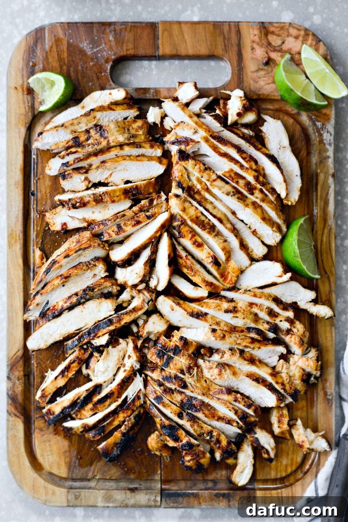 Signature Chipotle Chicken Marinade 12 Sliced chipotle chicken pieces, showcasing their juicy interior and perfectly seasoned crust, artfully arranged on a cutting board, ready for diverse culinary applications.