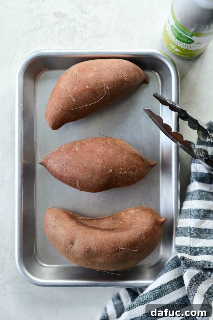 Caramelized Whole Sweet Potatoes 3 Sweet potatoes being sprayed with olive oil