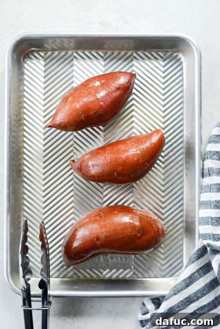 Caramelized Whole Sweet Potatoes 4 Sweet potatoes coated in olive oil on a baking sheet