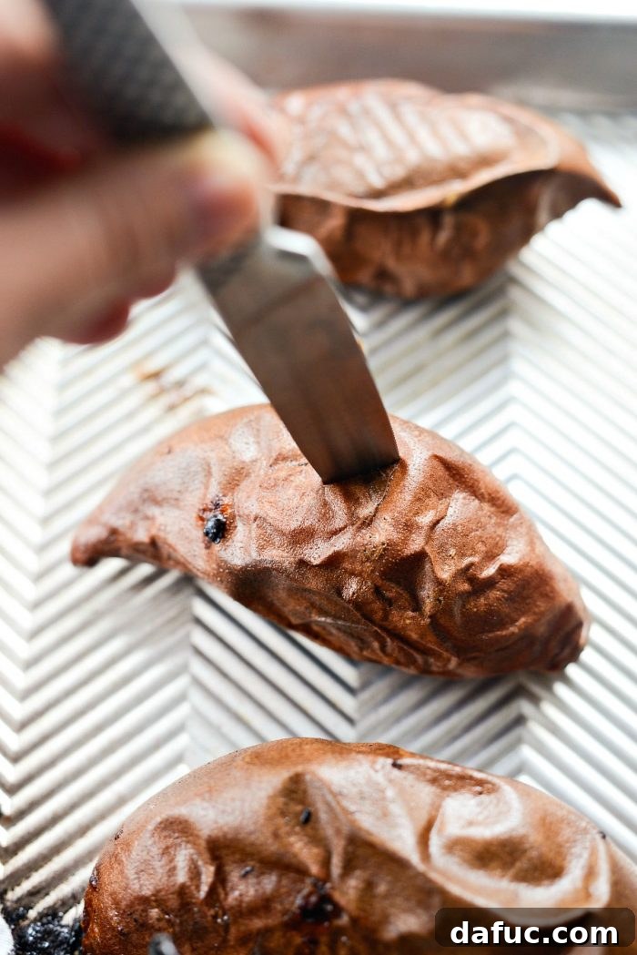 Caramelized Whole Sweet Potatoes 6 Knife testing the doneness of a roasted sweet potato