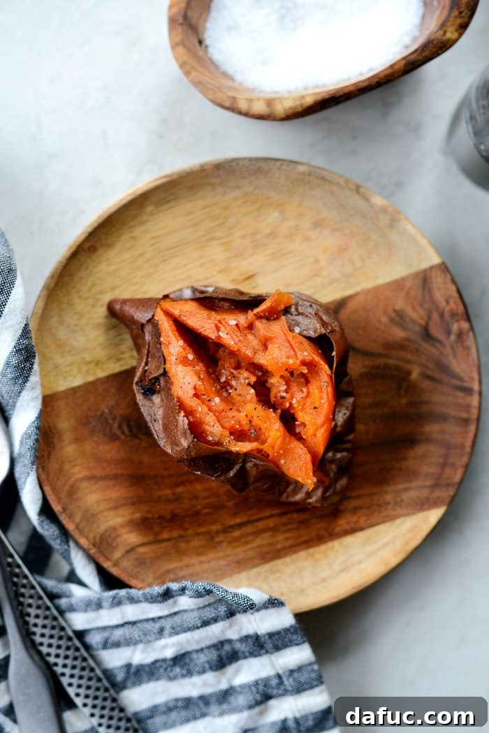 Caramelized Whole Sweet Potatoes 9 Two whole roasted sweet potatoes on a white plate, ready to be served