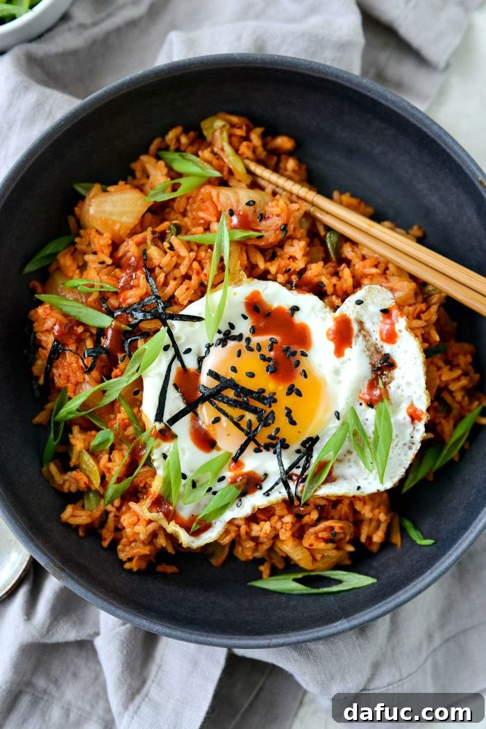 Ultimate Kimchi Fried Rice 2 Delicious Kimchi Fried Rice in a pan, ready to be served, garnished with fresh herbs.