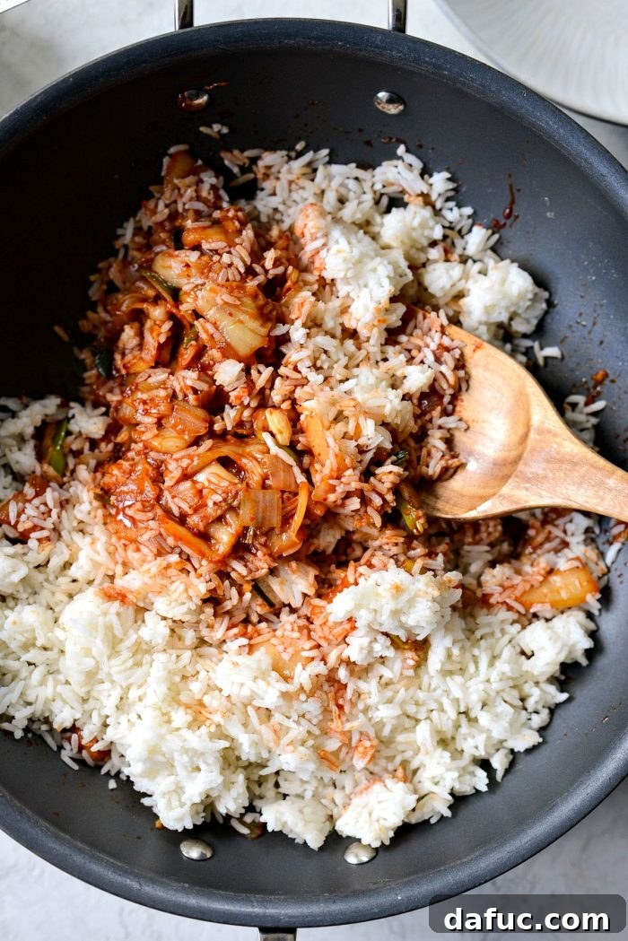 Ultimate Kimchi Fried Rice 13 Expertly tossing and coating the day-old rice with the kimchi stir-fry mixture in the wok.