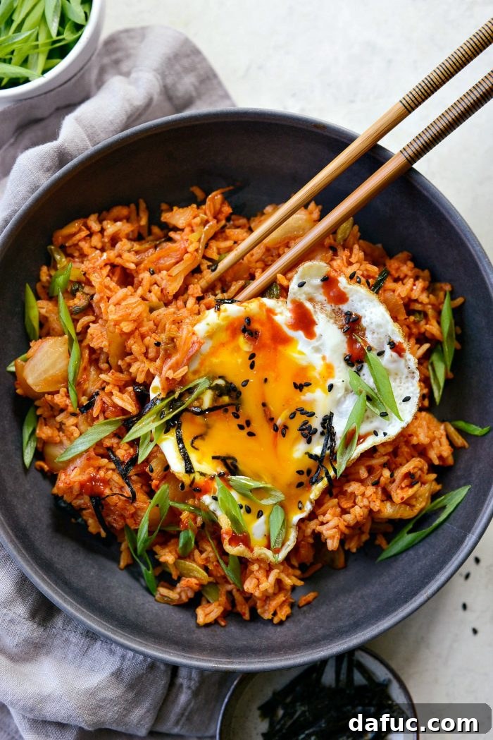 Ultimate Kimchi Fried Rice 20 A close-up of kimchi fried rice with a perfectly runny yolk, ready to be mixed in and savored.