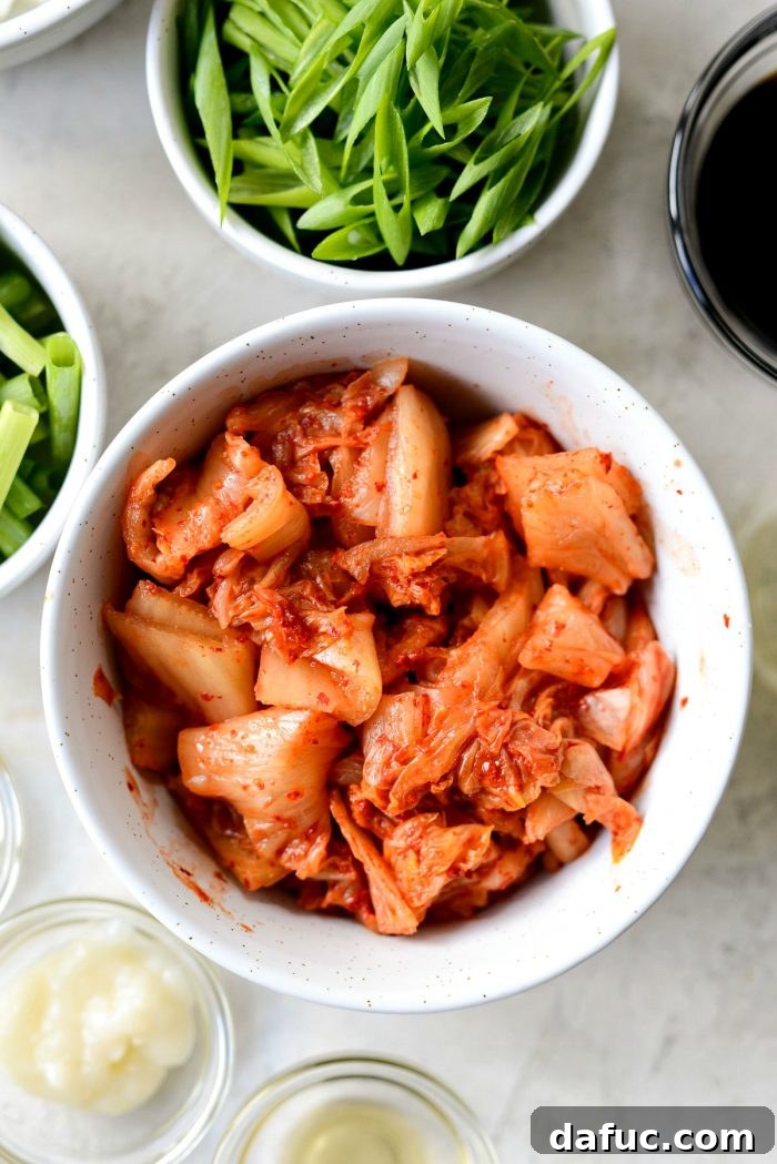 Ultimate Kimchi Fried Rice 5 A white ceramic bowl filled with vibrant red, freshly chopped kimchi.