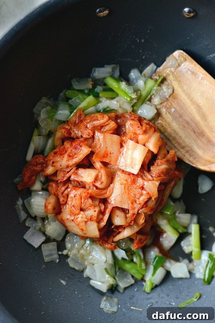 Ultimate Kimchi Fried Rice 9 Coarsely chopped kimchi added to the aromatic vegetables in a wok.