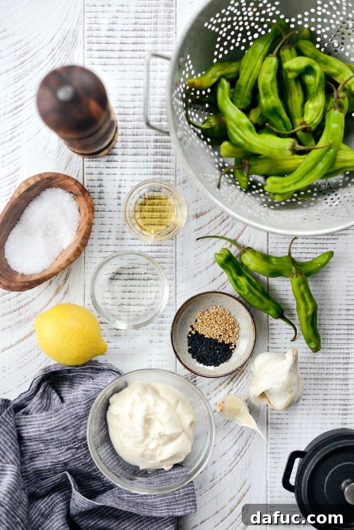 Sesame-Kissed Blistered Shishito Peppers with Zesty Lemon Garlic Aioli 4 An array of fresh shishito peppers and toasted sesame oil, laid out as ingredients for the dish