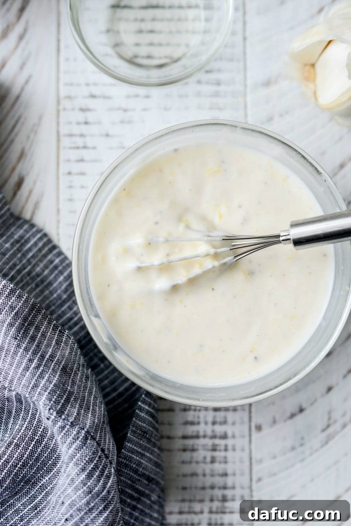 Sesame-Kissed Blistered Shishito Peppers with Zesty Lemon Garlic Aioli 6 The whisked lemon garlic aioli, showcasing its smooth and creamy texture in a glass bowl