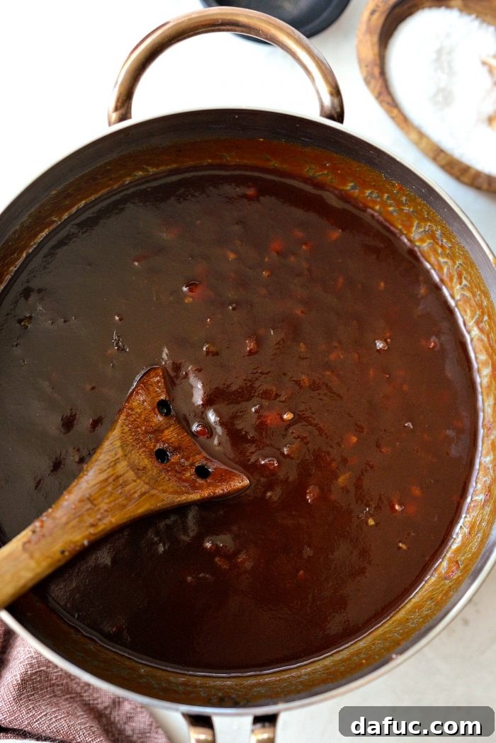 The Coca-Cola Habanero BBQ Sauce simmering gently after the tomato paste has been added.
