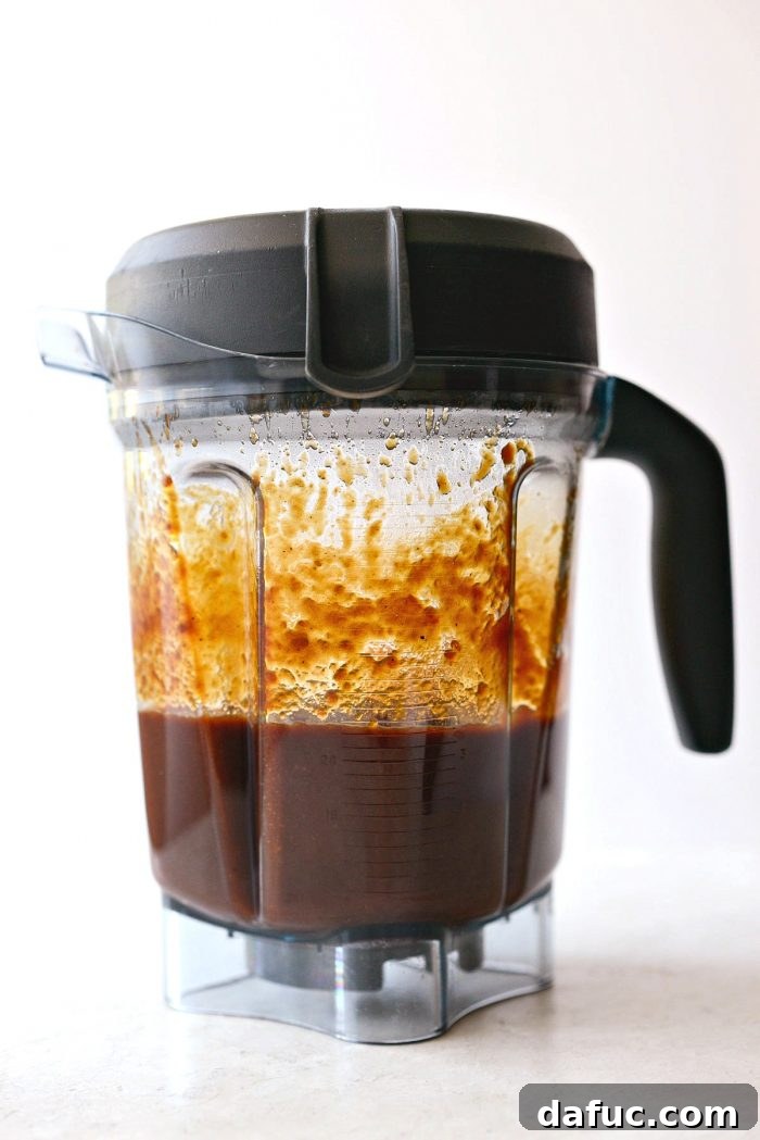 Pouring the cooled Coca-Cola Habanero BBQ Sauce into a blender for pureeing.