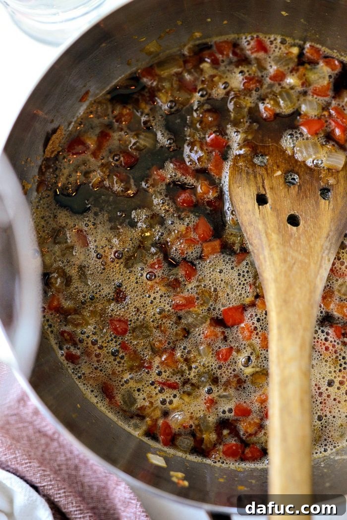 The Coca-Cola Habanero BBQ Sauce mixture simmering on the stovetop, bubbling gently.