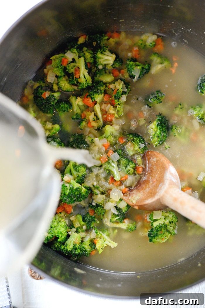 Hearty Ham, Swiss & Broccoli Delight 13 Low-sodium chicken broth being poured into the pot with the roux and vegetables.