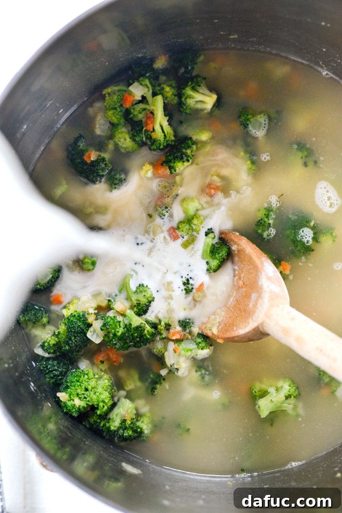 Hearty Ham, Swiss & Broccoli Delight 14 Half & half being poured into the simmering soup, adding richness and creaminess.