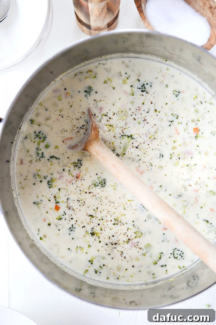 Hearty Ham, Swiss & Broccoli Delight 18 The finished creamy soup being seasoned with a sprinkle of kosher salt and a grind of fresh black pepper.