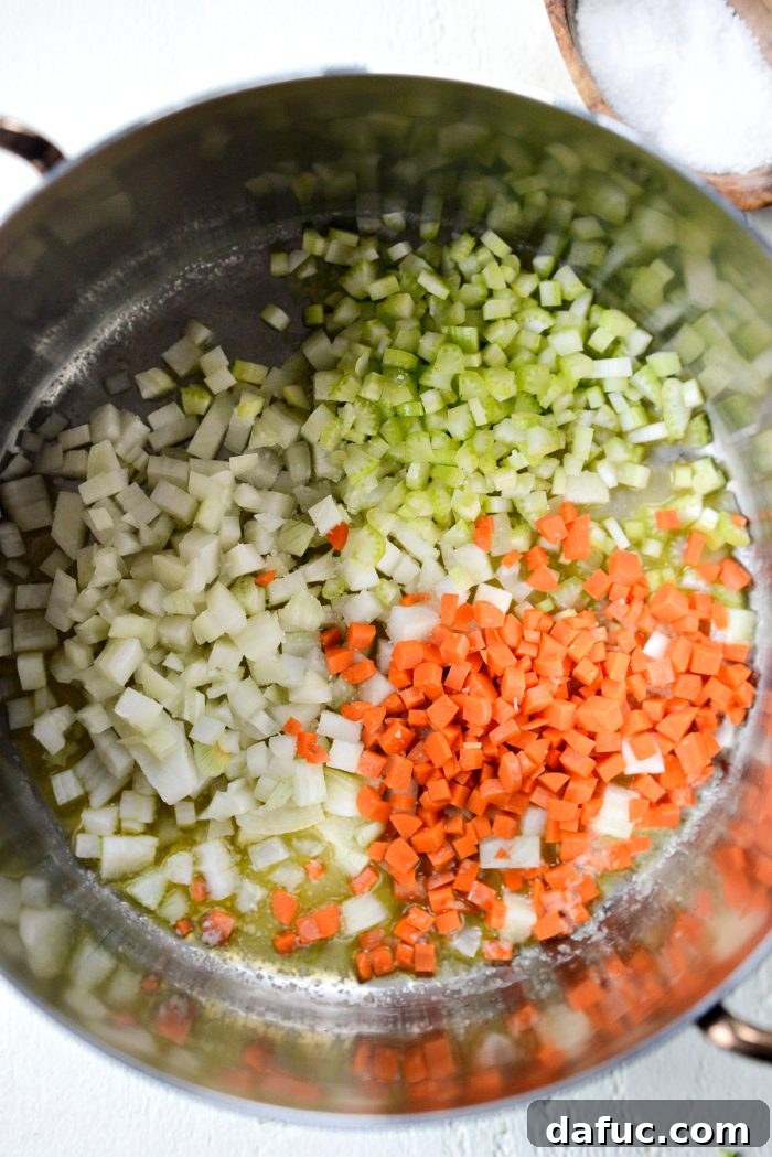 Hearty Ham, Swiss & Broccoli Delight 6 Diced onion, carrot, and celery being added to melted butter in a pot, starting the flavor base for the soup.