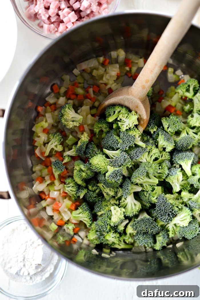 Hearty Ham, Swiss & Broccoli Delight 9 Broccoli florets added to the pot with sautéed vegetables, ready to be covered and cooked.