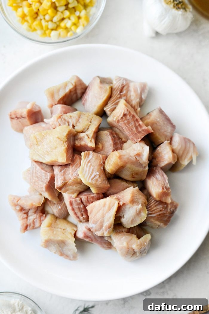 Coastal Catch Salmon Chowder 9 Fresh salmon fillet, with skin removed, cut into uniform 1 to 1.5-inch chunks on a cutting board.