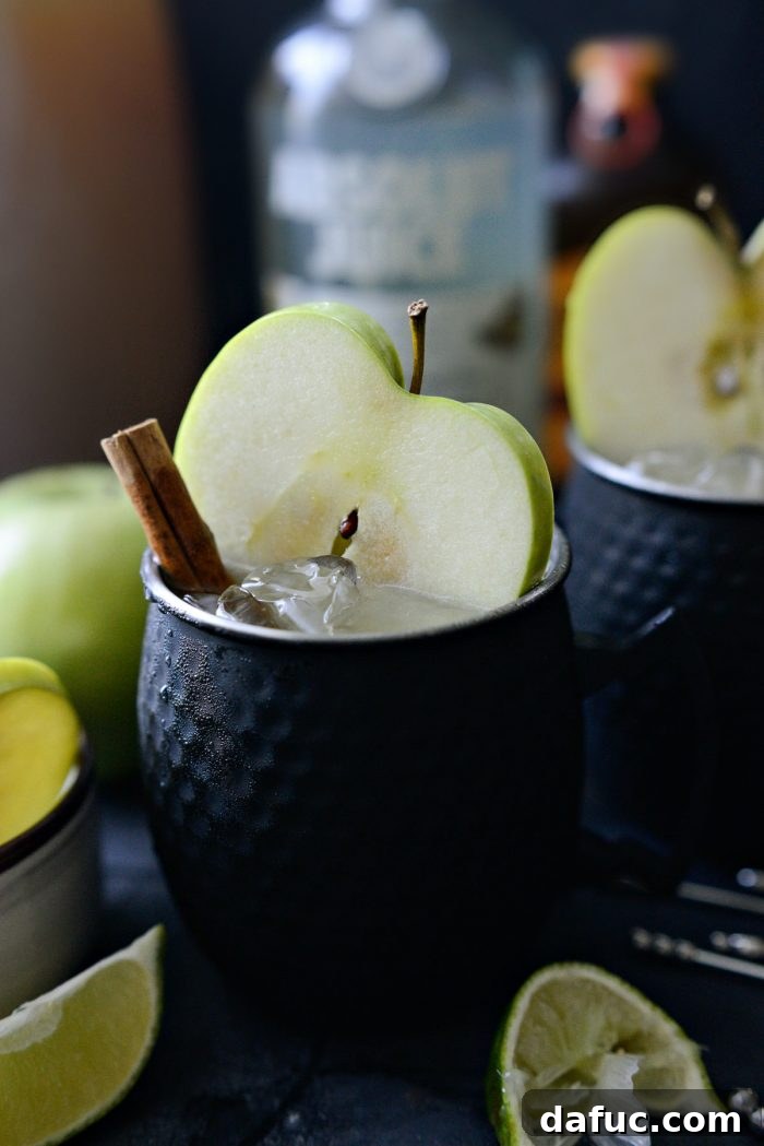 Orchard Mule 9 A close-up view of an Apple Cider Moscow Mule, showcasing its refreshing layers and inviting garnishes.
