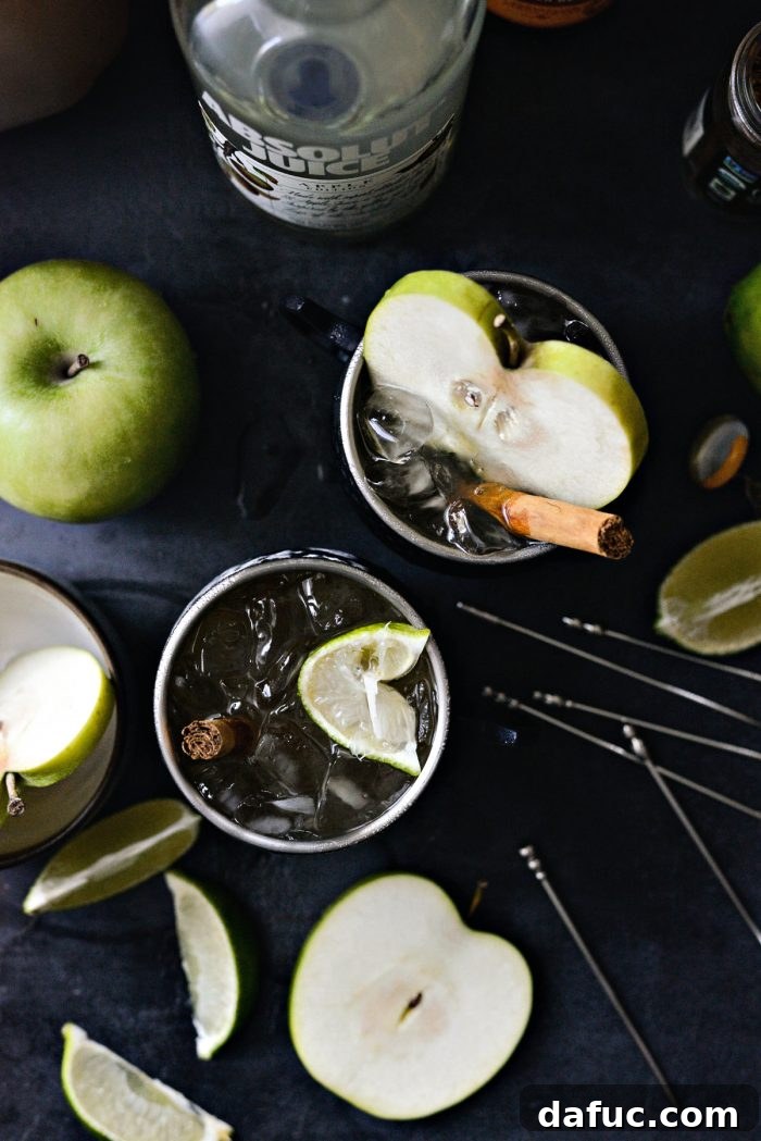 Orchard Mule 10 A top-down shot of two Apple Cider Moscow Mules, highlighting their vibrant colors and appealing garnishes, ready to be enjoyed.