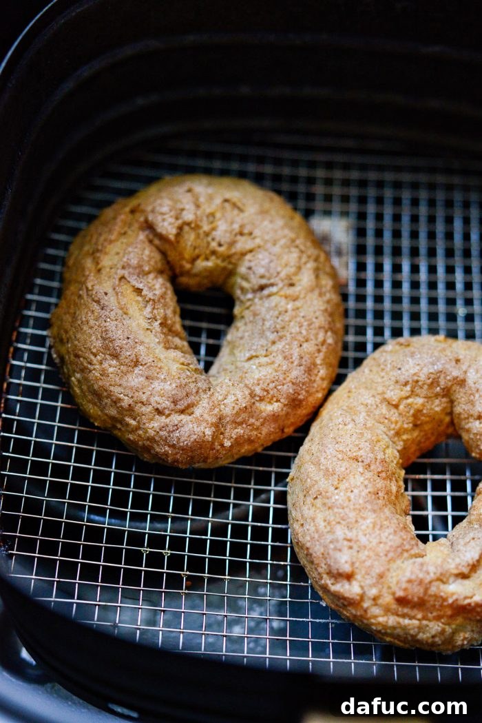 Delicious Air Fryer Pumpkin Spice Bagels 21 Two perfectly air-fried pumpkin spice bagels with a golden-brown crust.