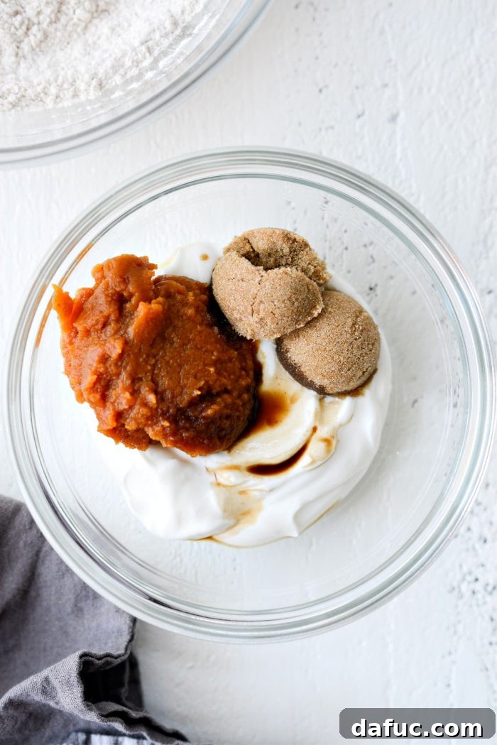 Delicious Air Fryer Pumpkin Spice Bagels 7 Wet ingredients for pumpkin spice bagels (Greek yogurt, pumpkin puree, brown sugar, vanilla extract) in a separate bowl.