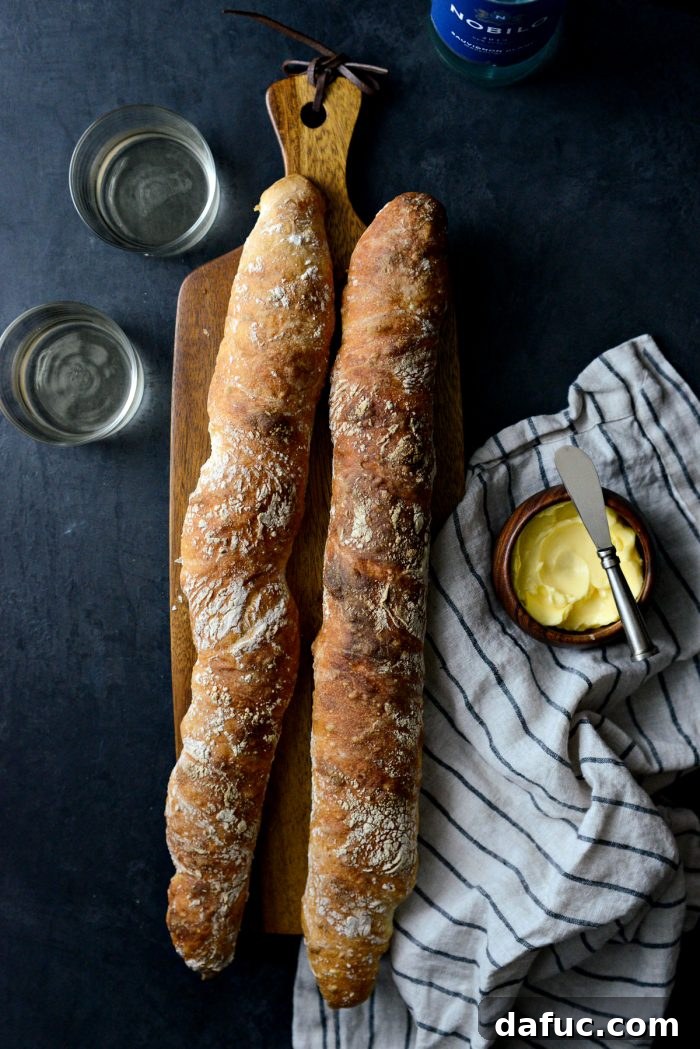 Freshly baked No-Knead French Bread baguettes on a cooling rack.