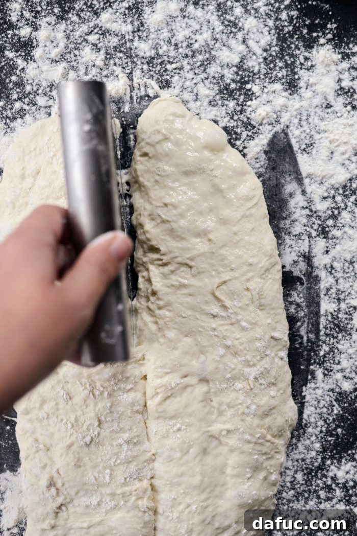 No-knead dough divided into two halves on a floured surface.
