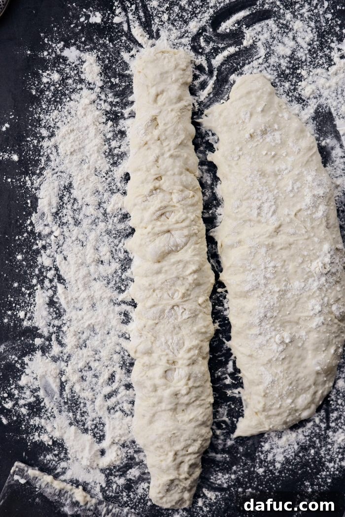 The result of pinching the dough, showing a more defined baguette shape.