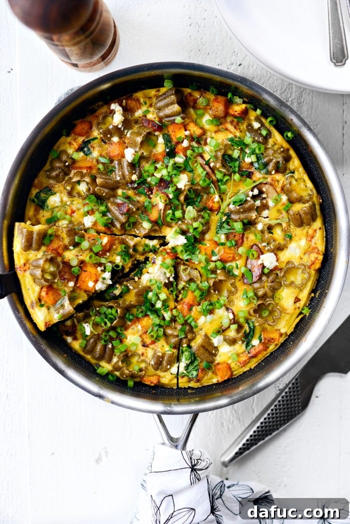 Roasted Pumpkin Kale and Feta Frittata topped with green onion and parsley.