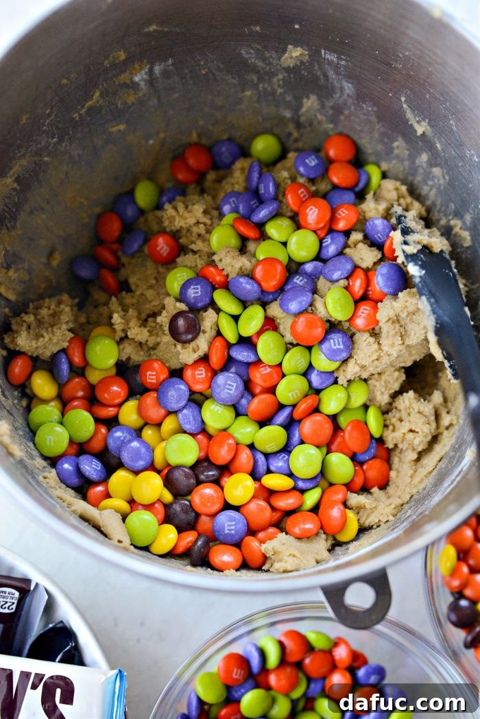 Halloween Haul Cookie Bars 13 Adding colorful Reese's Pieces and chocolate M&M's to the cookie bar batter.