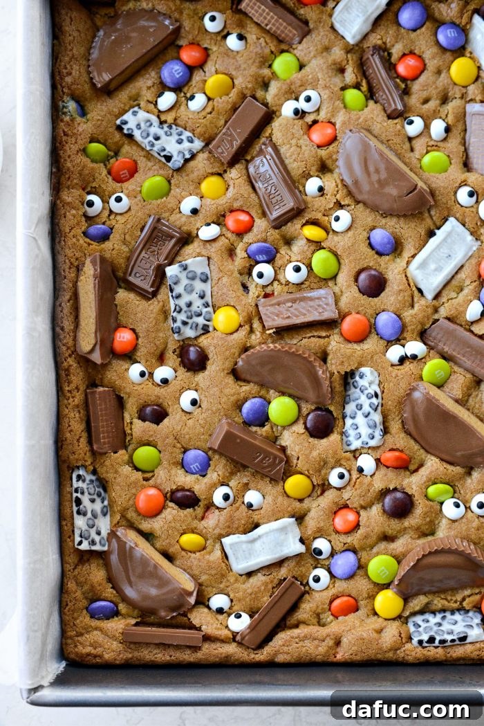 Halloween Haul Cookie Bars 19 A close-up shot of the finished Halloween Candy Cookie Bars, showing the colorful and spooky candy toppings.