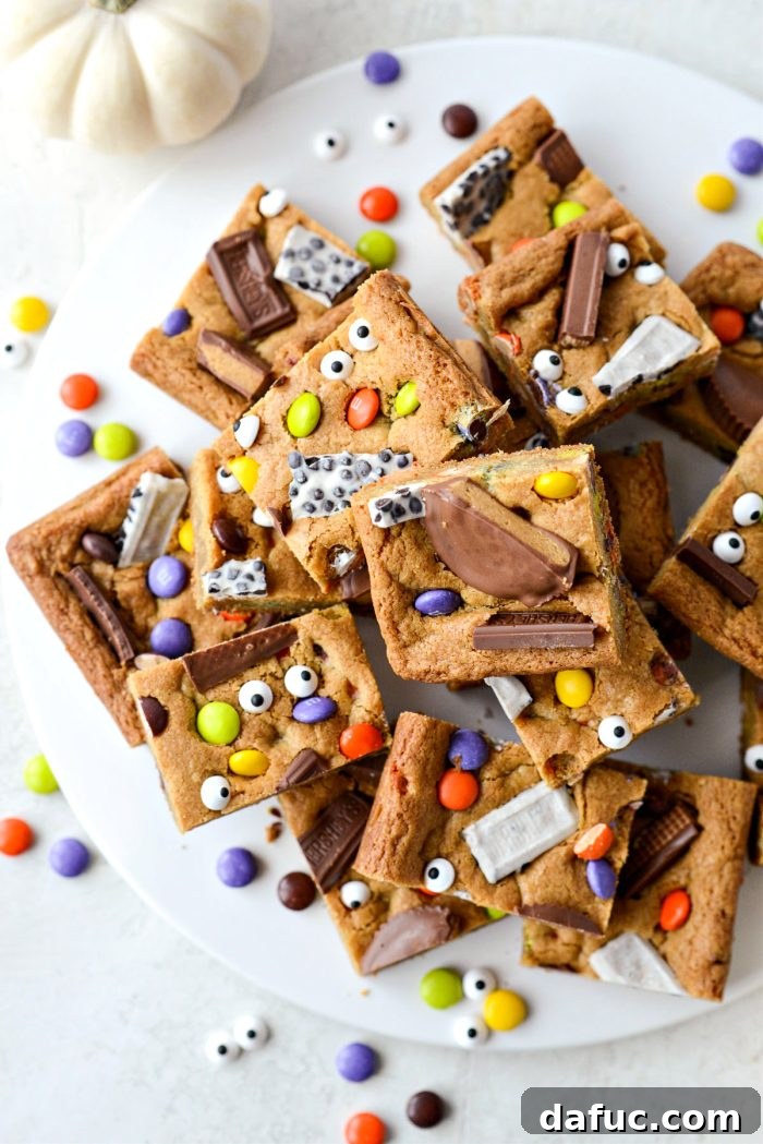Halloween Haul Cookie Bars 22 A beautifully arranged platter overflowing with festive Halloween Candy Cookie Bars, ready to be served.